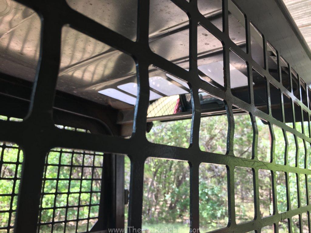 Photo of mirror from outside of track loader cage.
