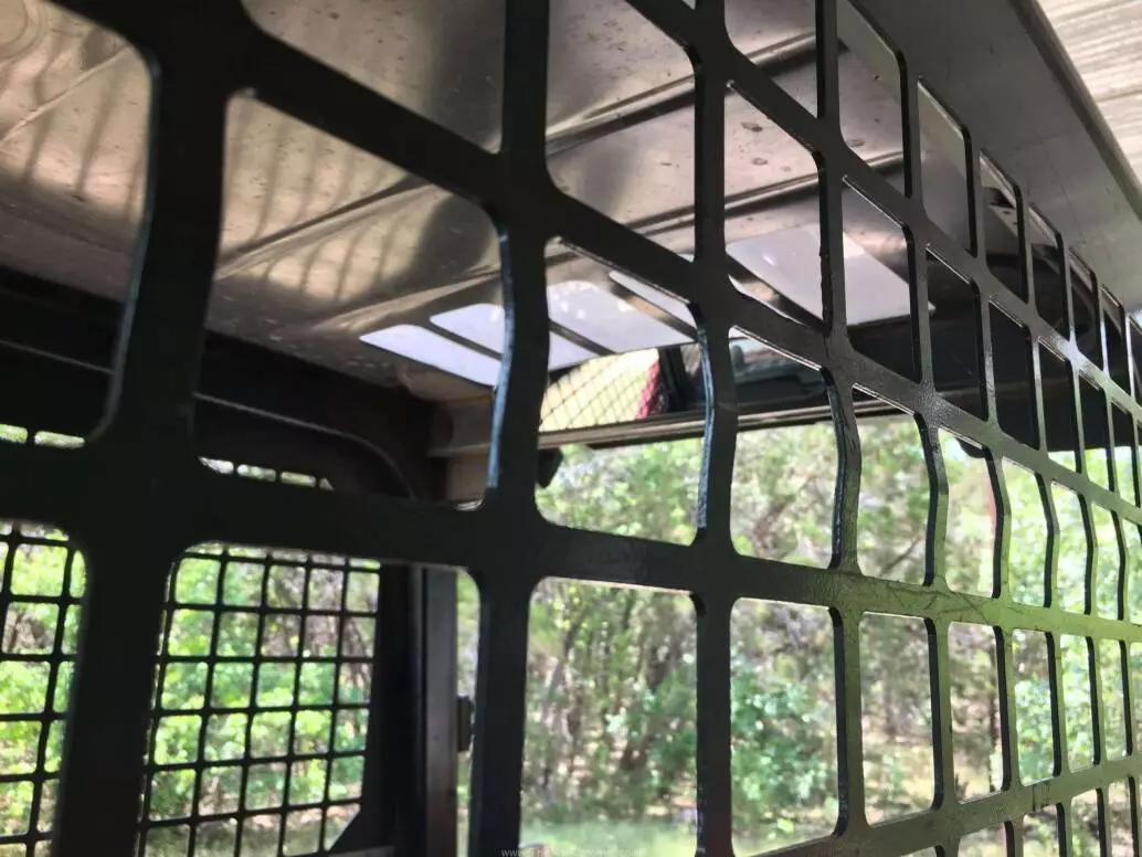 Photo of mirror from outside of track loader cage.