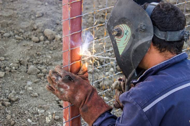 a-picture-containing-outdoor-ground-person-desc Welding fence panels onto a post